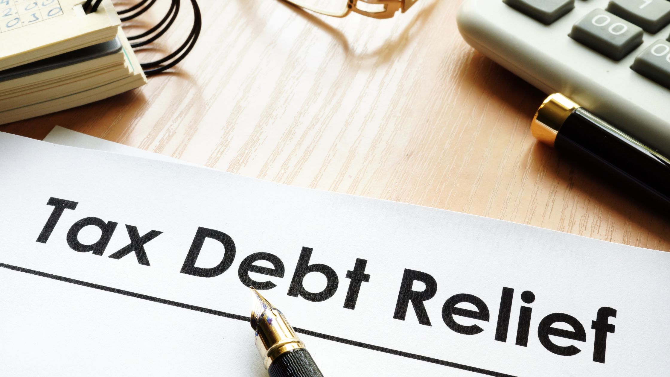 sign on desk says Tax Debt Relief